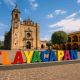 Calle empedrada tradicional con casas coloridas y fondo montañoso en Tlayacapan, Morelos